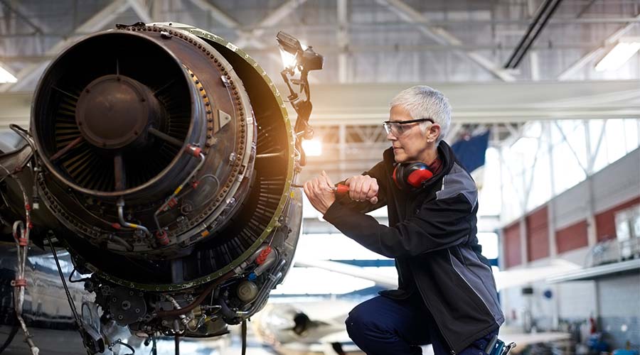woman working on an airplane engine