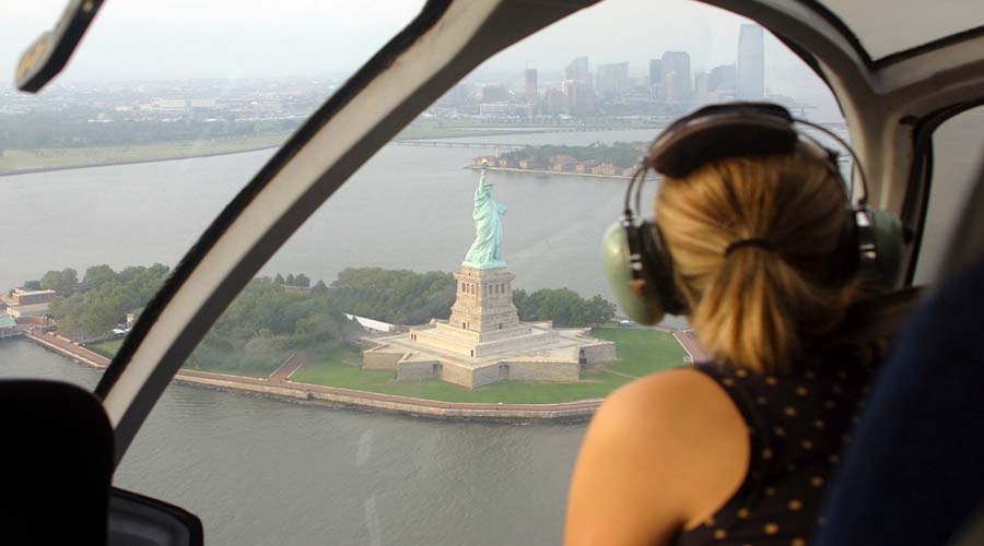 woman looking at the Statue of Liberty on a helicopter tour