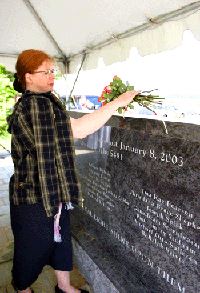 Tereasa Shepherd places flowers upon the Flight 5481 Memorial in honor of her daughter, Christiana